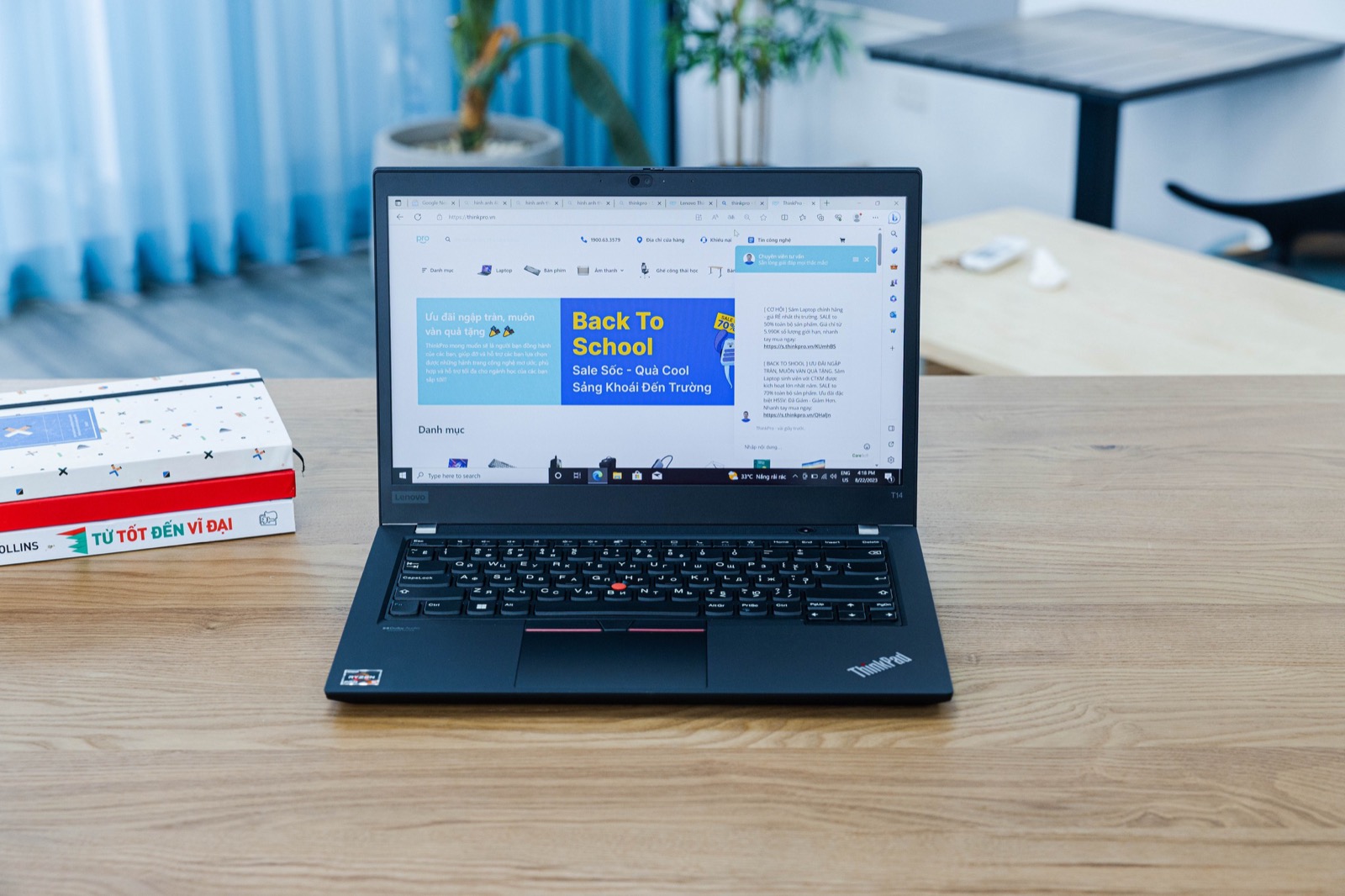 Otwarty czarny laptop Lenovo ThinkPad z serii T stojący na biurku, z charakterystycznym czerwonym trackpointem pośrodku klawiatury.
